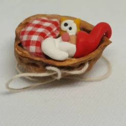 Baumschmuck Walnussschale Schaukelbettchen mit kleinem schlafend Wichtel mit roter Zipfelmütze und kleinem Stern