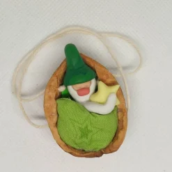 Baumschmuck Walnussschale Schaukelbettchen mit kleinem schlafend Wichtel mit Zipfelmütze und nachtleuchtendem Stern