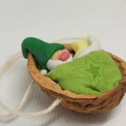 Baumschmuck Walnussschale Schaukelbettchen mit kleinem schlafend Wichtel mit Zipfelmütze und nachtleuchtendem Stern