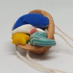 Baumschmuck Walnussschale Schaukelbettchen mit kleinem schlafend Wichtel mit nachtleuchtender Zipfelmütze und Stern