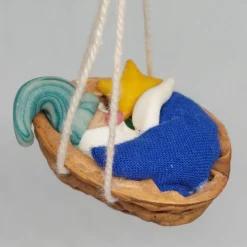 Baumschmuck Walnussschale Schaukelbettchen mit kleinem schlafend Wichtel mit nachtleuchtender Zipfelmütze und Stern