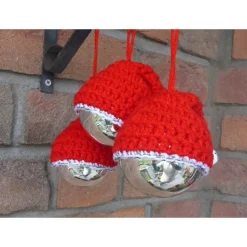 Drei Glasweihnachtsbaumkugel mit gehäkelten Nikolausmützen und Glöckchen