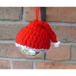 Drei Glasweihnachtsbaumkugel mit gehäkelten Nikolausmützen und Glöckchen