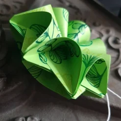 Dreidimensionale Geschenkanhänger aus Papier mit grünen Blättern – Origami Blüte in zwei Farben