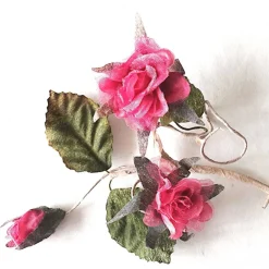 Duftiger Rosenzweig mit 3 Blüten, rosarot, als Deko auf einer Geschenkverpackung