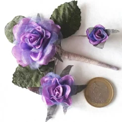 Duftiger Rosenzweig mit 3 Blüten, lila, als Deko auf einer Geschenkverpackung