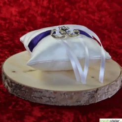 Elegantes Ringkissen aus weißem Satin mit lilanem Satinband und zarter weißer Schleife - Perfekte Hochzeitsdekoration