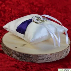Elegantes Ringkissen aus weißem Satin mit lilanem Satinband und zarter weißer Schleife - Perfekte Hochzeitsdekoration