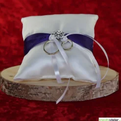 Elegantes Ringkissen aus weißem Satin mit lilanem Satinband und zarter weißer Schleife - Perfekte Hochzeitsdekoration