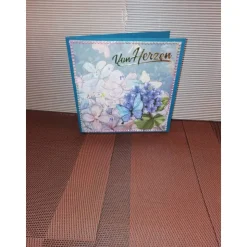 Geburtstagskarte in türkisblau für eine Frau mit Blumen und einem Schmetterling