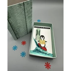 Geschenkbox Reisegeld: Surfender Pinguin als origineller Urlaubszuschuss