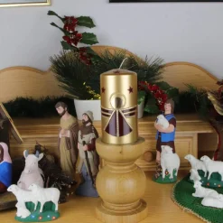 Goldene Weihnachtskerze mit weinrotem Engel