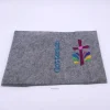 Gotteslobhülle, Filz, grau, bestickt mit dunkelrotem Kreuz und bunten Tropfen