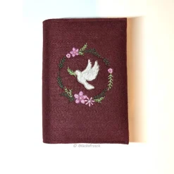 Gotteslobhülle, weinroter Filz mit mit Taube und Blütenkranz