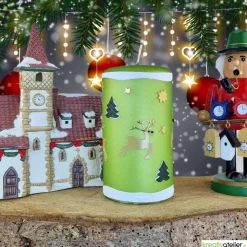 grüne Weihnachtskerze mit Rentieren, Tannen und Sternen