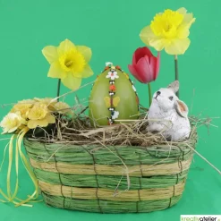 große Ostereikerze in grün mit doppelter, frühlingshafter Blumenranke verziert