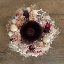 Haltbares Adventsgesteck mit Windlichtglas in kräftigen Beeren-, und rosatöne