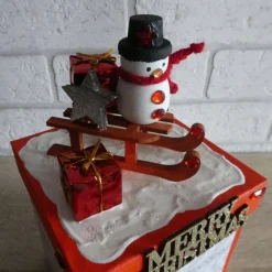 Handgefertigte Geschenkverpackung Schneemann auf Schlitten und Schriftzug Merry Christmas