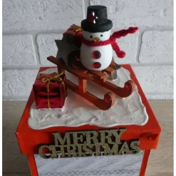 Handgefertigte Geschenkverpackung Schneemann auf Schlitten und Schriftzug Merry Christmas