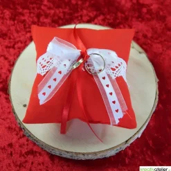 Handgefertigtes Ringkissen aus rotem Poppeline mit liebevoll angebrachter weißer Klöppelspitze und edlen Satinbändern