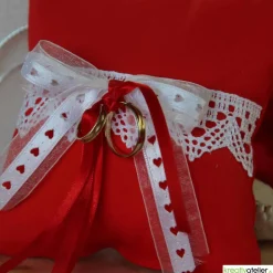 Handgefertigtes Ringkissen aus rotem Poppeline mit liebevoll angebrachter weißer Klöppelspitze und edlen Satinbändern
