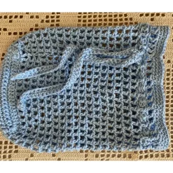 Hellblaues Häkelnetz für kleine Schätze oder als umweltfreundliche Verpackung für ein Geschenk