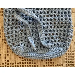 Hellblaues Häkelnetz für kleine Schätze oder als umweltfreundliche Verpackung für ein Geschenk