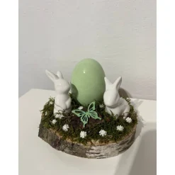 Osterdeko auf einer Baumscheibe Hasen grün