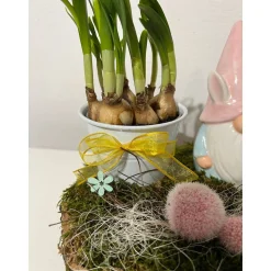 Osterdeko auf einer Baumscheibe mit Blumentopf und einem Wichtel