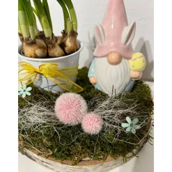 Osterdeko auf einer Baumscheibe mit Blumentopf und einem Wichtel