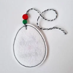 Osterei aus Filz mit zwei Holzperlen - FROHE OSTERN in Schreibschrift - von he-ART by helen hesse