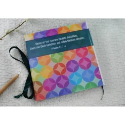 personalisiertes farbenfrohes Gästebuch zur Kommunion mit Fischen und Kreisen in Regenbogenfarben auch mit Gästefragen