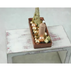 Rechteckige goldene  Platte mit beiger Kerze in weihnachtlicher  Dekoration