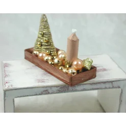 Rechteckige goldene  Platte mit beiger Kerze in weihnachtlicher  Dekoration