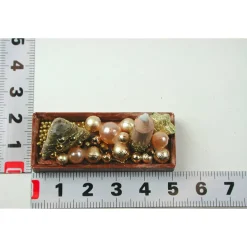 Rechteckige goldene  Platte mit beiger Kerze in weihnachtlicher  Dekoration