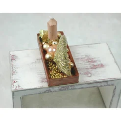 Rechteckige goldene  Platte mit beiger Kerze in weihnachtlicher  Dekoration