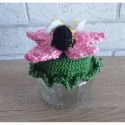 Schönes Glas mit Schraubverschluss, gehäkelter Blume und Biene