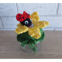 Schönes Glas mit Schraubverschluss, gehäkelter Blume und Marienkäfer