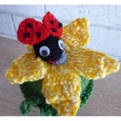 Schönes Glas mit Schraubverschluss, gehäkelter Blume und Marienkäfer