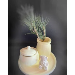 Set aus Teddy, Töpfchen und kleiner Vase auf einem runden Tablett