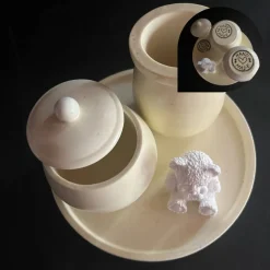 Set aus Teddy, Töpfchen und kleiner Vase auf einem runden Tablett