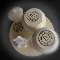 Set aus Teddy, Töpfchen und kleiner Vase auf einem runden Tablett