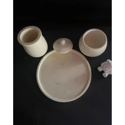 Set aus Teddy, Töpfchen und kleiner Vase auf einem runden Tablett