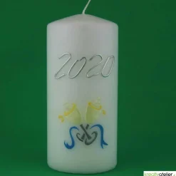Weiße Silvesterkerze mit Jahreszahl und Sektgläsern