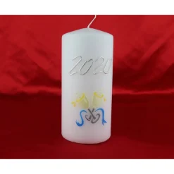 Weiße Silvesterkerze mit Jahreszahl und Sektgläsern