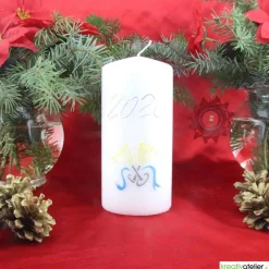 Weiße Silvesterkerze mit Jahreszahl und Sektgläsern