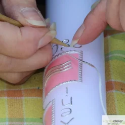 Weiße Taufkerze mit Kreuz und Taube, Fischen und Welle jeweils auf drei farbigen Kacheln, blau oder rosa