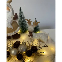 Weihnachtsdeko auf Baumscheibe mit Weihnachtsmann und Reh