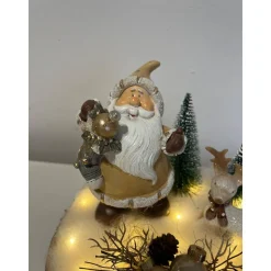 Weihnachtsdeko auf Baumscheibe mit Weihnachtsmann und Reh