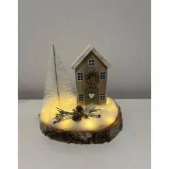 Weihnachtsdeko auf einer Baumscheibe mit einem Häuschen